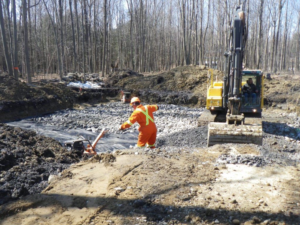 Travailleur en combinaison de protection sur un chantier d'excavation de sols contaminés