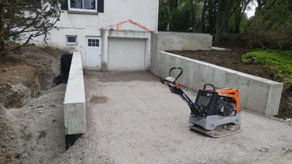 Plaque vibrante compactant le matériel granulaire d'une entrée de voiture
