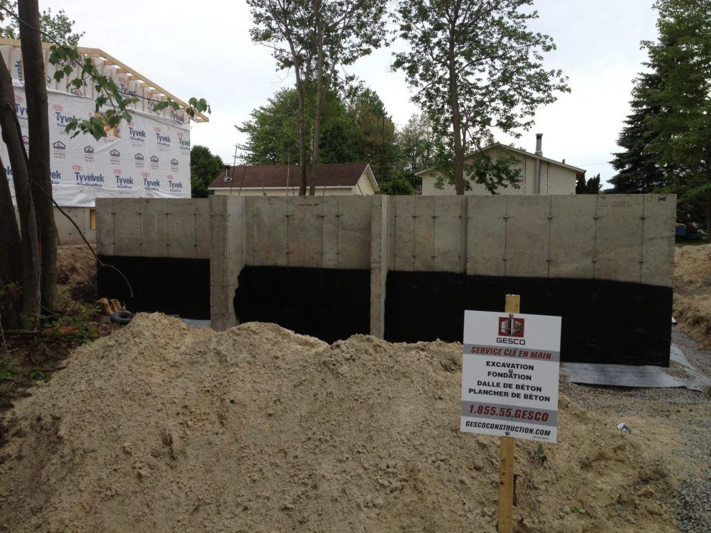 Mur de fondation en béton coulé avec membrane d'imperméabilisation noire appliquée