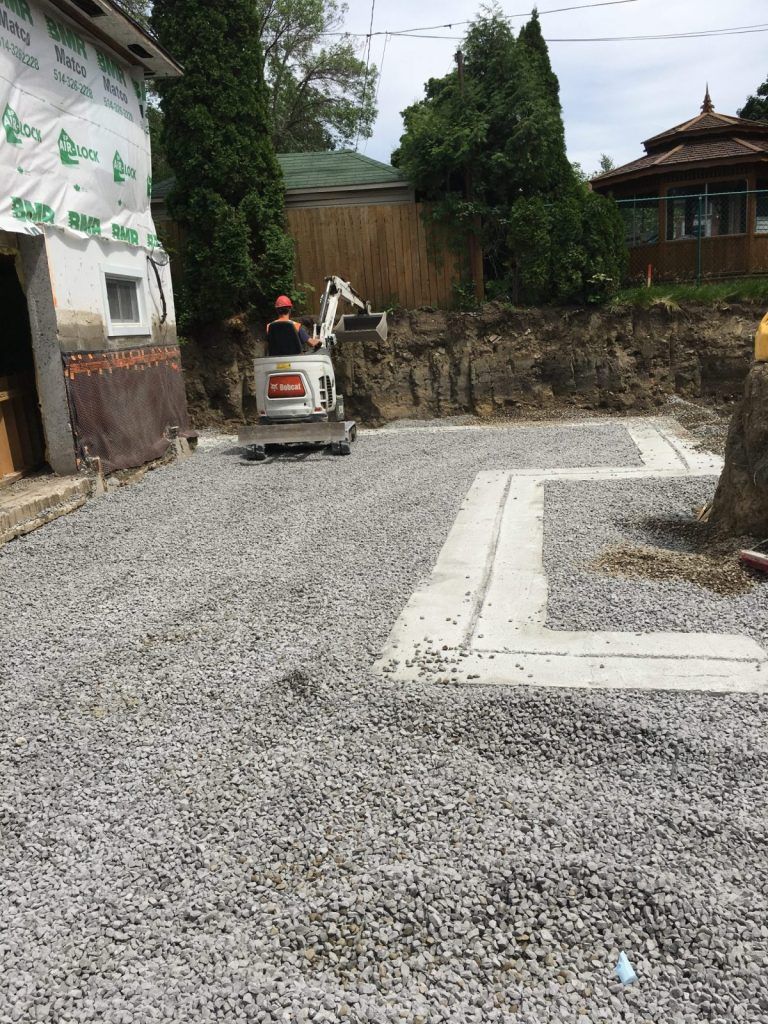 Cour arrière nivelée avec surface de pierre concassée et bordure de béton