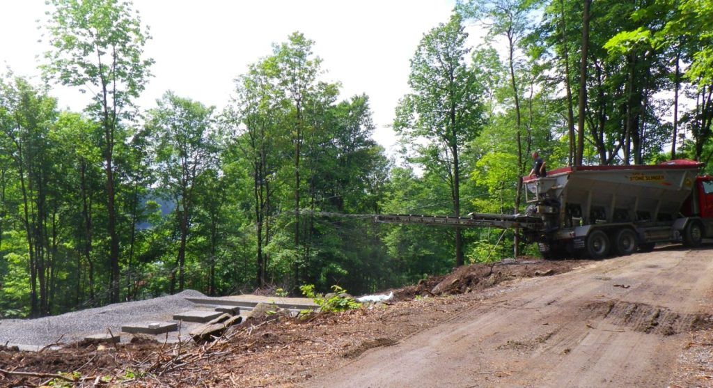 Terrain en préparation avec camion benne dans un secteur boisé